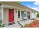 Inviting front porch with seating area and a vibrant red door at 8600 Village Mill Row, Hudson, FL 34667