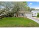 Inviting home with lush lawn, mature tree, and an attached garage at 8600 Village Mill Row, Hudson, FL 34667