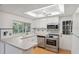 Bright kitchen with stainless steel appliances, white cabinets, and a window view at 8600 Village Mill Row, Hudson, FL 34667