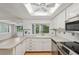 Bright kitchen view features stainless steel appliances, a window and white cabinetry at 8600 Village Mill Row, Hudson, FL 34667