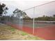 A red and green tennis court with a high fence at 8600 Village Mill Row, Hudson, FL 34667
