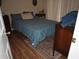 Cozy bedroom featuring wood floors, a comfortable bed with blue linens, and ample natural light at 8600 Village Mill Row, Hudson, FL 34667