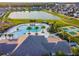 Aerial view showcases a community pool, tennis courts, clubhouse, playground, lake and manicured grounds at 11504 Sage Canyon Dr, Riverview, FL 33578