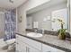 Bathroom featuring granite counters, white cabinets, a shower/tub with curtain, and an adjacent commode at 11504 Sage Canyon Dr, Riverview, FL 33578