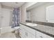 Well-lit bathroom featuring granite countertop, white cabinetry, and shower-tub combo at 11504 Sage Canyon Dr, Riverview, FL 33578