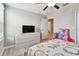 Bright bedroom with light walls and floors, features a ceiling fan, and includes a toy-filled doorway at 11504 Sage Canyon Dr, Riverview, FL 33578