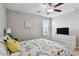 Cozy bedroom featuring light walls, light floors, a ceiling fan, and a large window at 11504 Sage Canyon Dr, Riverview, FL 33578