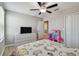 Bedroom with wood-look floors, closet, TV and ceiling fan at 11504 Sage Canyon Dr, Riverview, FL 33578