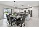 Open-concept dining area with modern table, seating for six, adjacent to a bright kitchen and outdoor view at 11504 Sage Canyon Dr, Riverview, FL 33578