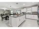 Open-concept kitchen with granite island, stainless appliances, and white cabinets, connected to the dining and living areas at 11504 Sage Canyon Dr, Riverview, FL 33578
