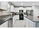 Modern kitchen featuring stainless steel appliances, granite countertops, and white cabinetry creating a clean and functional space at 11504 Sage Canyon Dr, Riverview, FL 33578