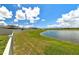 Serene view of a lake with a grassy shoreline at 11504 Sage Canyon Dr, Riverview, FL 33578