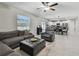 Open-concept living room features a large sectional sofa, leather recliner, and view of the kitchen at 11504 Sage Canyon Dr, Riverview, FL 33578