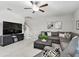 Cozy living room with a sectional sofa, ceiling fan, and large TV, leading to the staircase at 11504 Sage Canyon Dr, Riverview, FL 33578