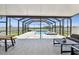 Covered patio featuring a screen enclosure, comfortable outdoor seating, and a view of the pool at 11504 Sage Canyon Dr, Riverview, FL 33578