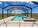 Enclosed pool and hot tub combo with brick paver decking, lake view, and blue skies above at 11504 Sage Canyon Dr, Riverview, FL 33578
