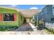 View of the house exterior with a covered patio, showcasing colorful columns and lush landscaping at 121 86Th Ter, Treasure Island, FL 33706