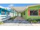 View of the exterior patio with a white ceiling fan, colorful columns, and a small garden near the home at 121 86Th Ter, Treasure Island, FL 33706