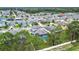Aerial view of a neighborhood showcasing houses with grey roofs and green trees, plus a home with a screened pool at 12134 Creek Preserve Dr, Riverview, FL 33579