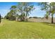 Large grassy backyard is enclosed with a white fence and framed by mature trees for added privacy at 12134 Creek Preserve Dr, Riverview, FL 33579