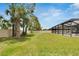 Expansive backyard view showcasing lush green grass, mature trees, and a partial view of the screened-in pool at 12134 Creek Preserve Dr, Riverview, FL 33579