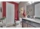 Charming bathroom with red accent wall, granite vanity, and decorative shelving at 12134 Creek Preserve Dr, Riverview, FL 33579