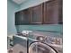 Well-equipped laundry room with storage cabinets, washer, and dryer at 12134 Creek Preserve Dr, Riverview, FL 33579