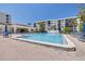 Community pool surrounded by lounging chairs and palm trees at 1328 Pasadena S Ave # 608, South Pasadena, FL 33707