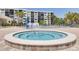 Inviting hot tub surrounded by pools and comfortable lounge chairs, set against a backdrop of palm trees and buildings at 1328 Pasadena S Ave # 608, South Pasadena, FL 33707