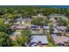 An aerial view showcases the neighborhood's houses with pools, solar panels, and lush greenery at 135 Coral Dr, Safety Harbor, FL 34695