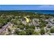 This aerial view displays the property nestled in a tree-lined neighborhood near a scenic body of water at 135 Coral Dr, Safety Harbor, FL 34695