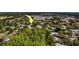 The aerial view showcases community homes nestled within a backdrop of trees and neighborhood streets at 135 Coral Dr, Safety Harbor, FL 34695