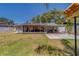 Fenced-in backyard with a screened lanai, patio, and mature trees at 135 Coral Dr, Safety Harbor, FL 34695