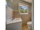 Bathroom featuring neutral tiling, a sink with a white countertop, and a toilet at 135 Coral Dr, Safety Harbor, FL 34695