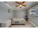 Comfortable bedroom includes gray plank flooring and ceiling fan at 135 Coral Dr, Safety Harbor, FL 34695