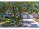 Attractive single-story home featuring mature trees, a manicured lawn, and a private driveway at 135 Coral Dr, Safety Harbor, FL 34695