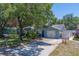 Quaint single-story home boasting a manicured lawn, mature trees, and a private driveway at 135 Coral Dr, Safety Harbor, FL 34695