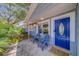 Charming front porch with blue chairs, patterned tile, and a vibrant blue door at 135 Coral Dr, Safety Harbor, FL 34695