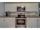 Close-up of kitchen featuring granite counters, white cabinets, and stainless steel appliances at 135 Coral Dr, Safety Harbor, FL 34695