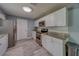 Bright kitchen featuring granite counters, white cabinets, stainless appliances and gray wood-look floors at 135 Coral Dr, Safety Harbor, FL 34695