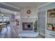 Living room with gray floors, a stone fireplace with a plant, and an open kitchen at 135 Coral Dr, Safety Harbor, FL 34695