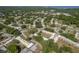 An aerial view of a property showing landscaping, roof lines and surrounding neighborhood with mature trees at 1472 Mission Hills Blvd # 24F, Clearwater, FL 33759