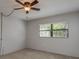 This bedroom features neutral walls, carpet, and a ceiling fan with a light at 1472 Mission Hills Blvd # 24F, Clearwater, FL 33759