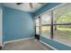 Bedroom featuring blue walls, a ceiling fan, and a window overlooking the outdoors at 1472 Mission Hills Blvd # 24F, Clearwater, FL 33759