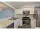 Well-lit kitchen featuring stainless steel appliances, white cabinets, and a double sink at 1472 Mission Hills Blvd # 24F, Clearwater, FL 33759