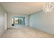 Open-concept living room with neutral carpet, large window, and modern light fixture creates a relaxing ambiance at 1472 Mission Hills Blvd # 24F, Clearwater, FL 33759