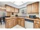 Well-lit kitchen with wood cabinets, a double sink, and stainless steel dishwasher at 16309 Caliente Pl, Tampa, FL 33624