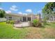 Landscaped backyard featuring a brick patio with fireplace, pergola, and adjacent lawn at 17124 Falconridge Rd, Lithia, FL 33547