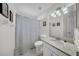 Bathroom with granite countertop, modern fixtures, mirror, and a shower with decorative curtain at 17124 Falconridge Rd, Lithia, FL 33547