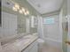 Well-lit bathroom featuring a granite countertop vanity and shower over tub combination at 17124 Falconridge Rd, Lithia, FL 33547